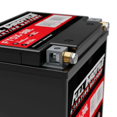 Close-up of a black Full Throttle car battery with red labels, showing metal terminals on top.