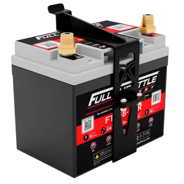 A black and gray automotive battery with red labels, two terminal posts, and a black carrying handle.