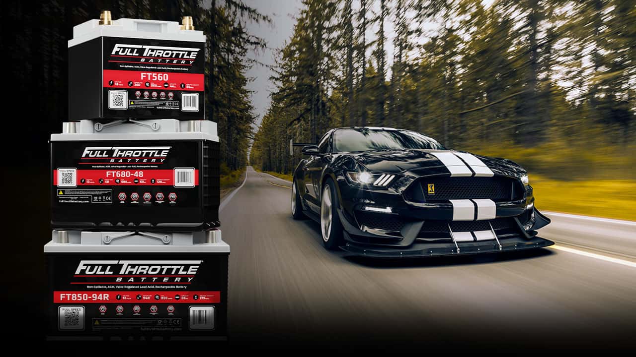 Stack of Full Throttle batteries on the left with a black sports car driving on a forest road in the background.