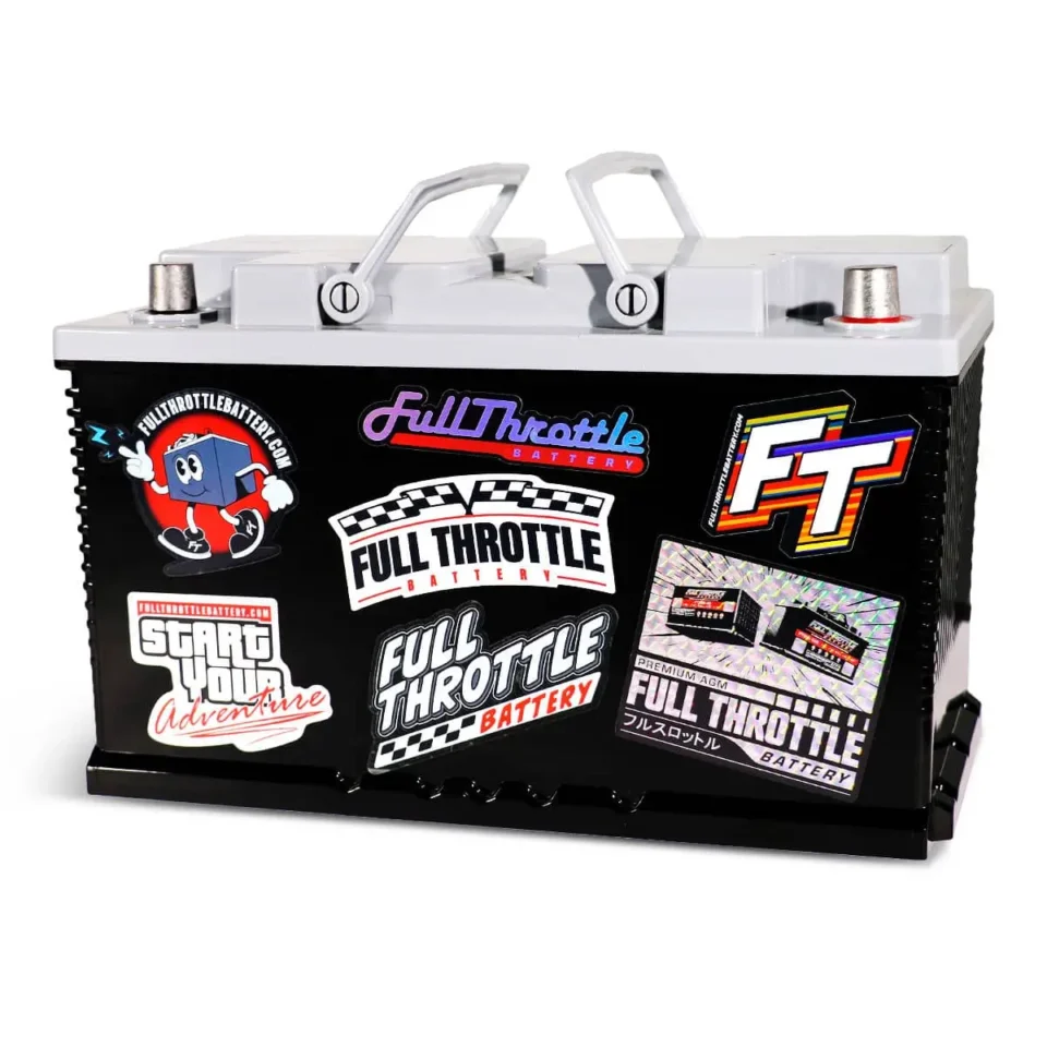 A black battery with a gray top covered in various colorful stickers, including logos and designs related to "Full Throttle Battery.