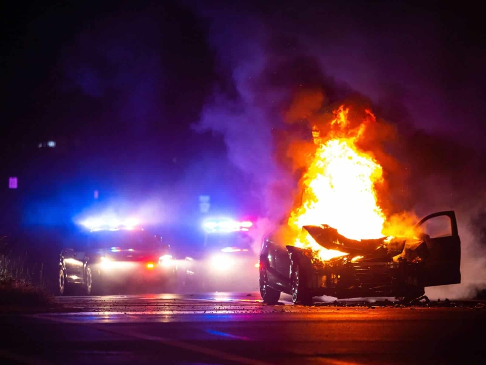 Emergency vehicles responding to a vehicle fire at night