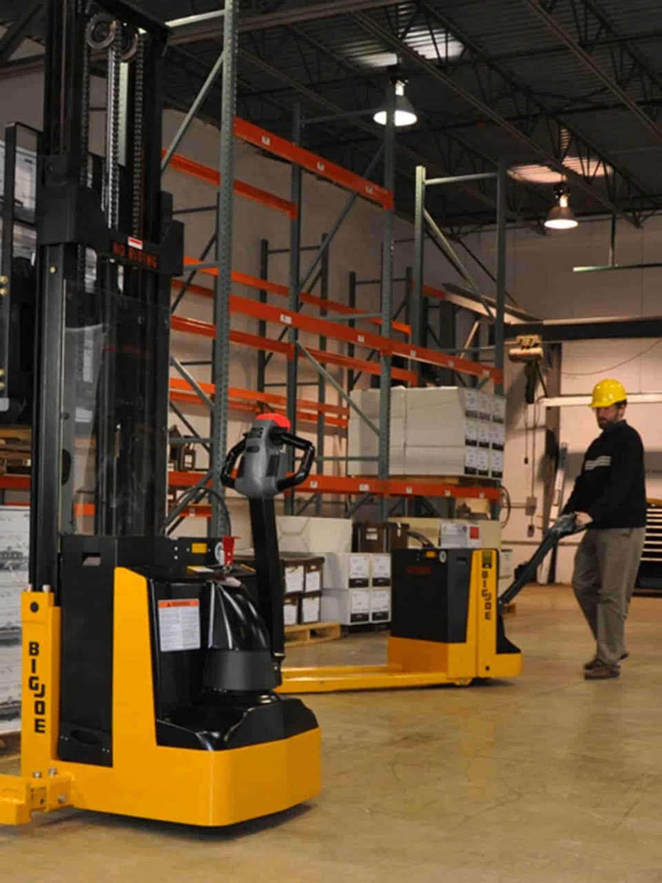 Man using an electric pallet jack in warehouse