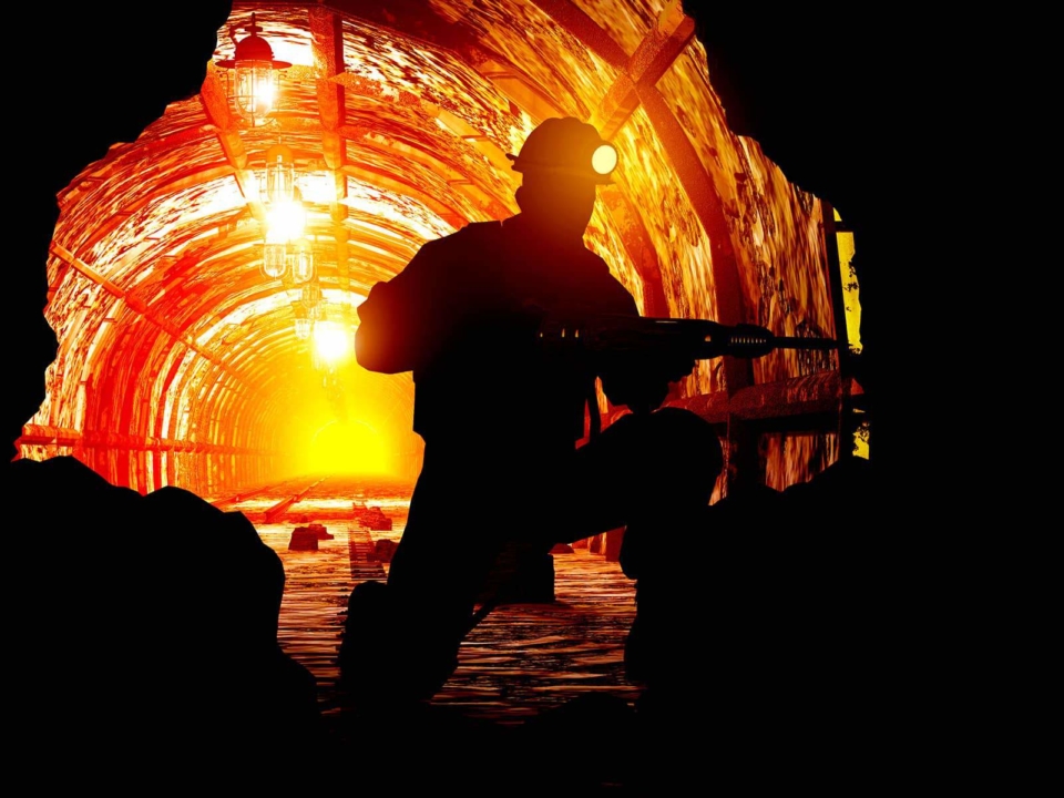 Miner working in the tunnels using battery powered lighting