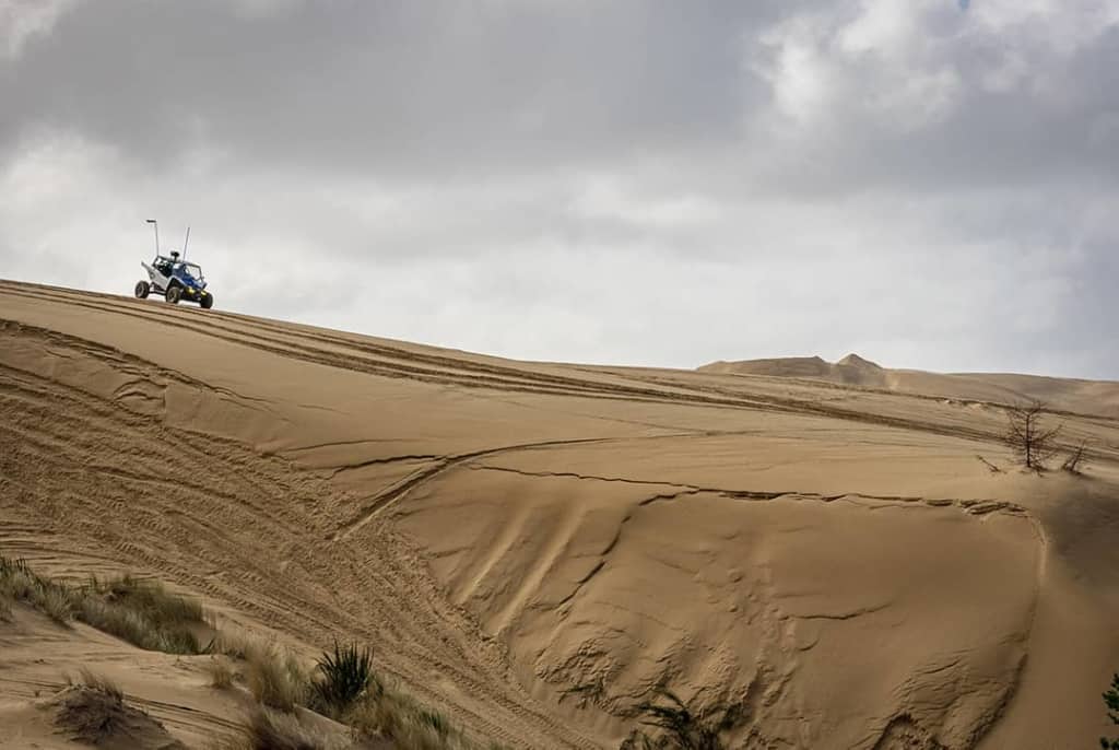 A UTV sits on top of a large dune during a gloomy day in Winchester, Oregon.