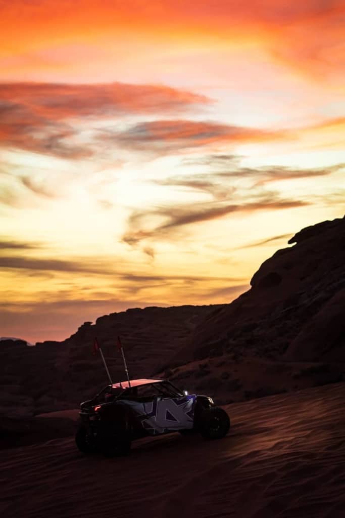 The Amped UTV on a sand dune during sunset.